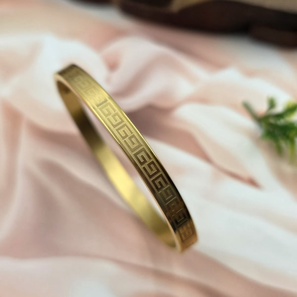 Gold-toned metal bangle or bracelet.