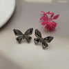 Silver-toned or gunmetal butterfly stud earrings.